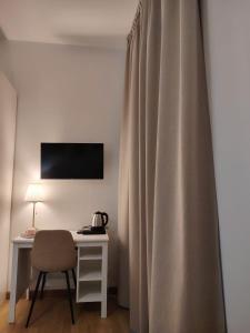 a desk with a chair next to a curtain at Affittacamere Borgo Antico in Venzone
