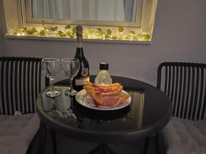 a table with a bottle of wine and a plate of food at Stan na dan - SResidence Banja Luka in Banja Luka