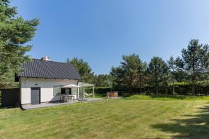 a small white house with a large yard at LAS i MORZE in Czarny Młyn