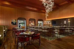 a restaurant with tables and chairs and a bar at Hotel Mockingbird, Dallas, a Tribute Portfolio Hotel in Dallas