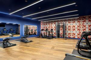 a gym with several treadmills and machines in a room at Hotel Mockingbird, Dallas, a Tribute Portfolio Hotel in Dallas