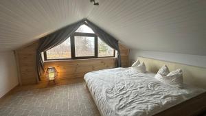 a bedroom with a large bed with a window at Little H Family in Dealu Mare