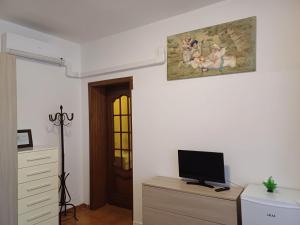 a room with a tv on a dresser with a painting on the wall at Luna in Novara