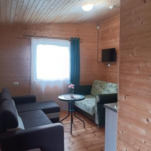 a living room with a couch and a table at Liepsna Šventoji in Šventoji