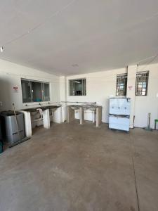 an empty room with tables and counters in it at BG Hospedagens in Paracatu