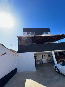 a white car parked in front of a house at BG Hospedagens in Paracatu +4 photos