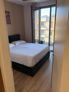 a bedroom with a bed and a large window at SL Apartment in Tirana