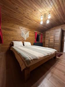 a bedroom with a large bed with a wooden ceiling at Çambaşı Villa Bella in Ordu