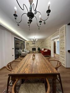 a dining room with a wooden table and a chandelier at Çambaşı Villa Bella in Ordu