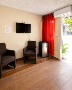a waiting room with two chairs and a flat screen tv at Hotel restaurant bon Appetit in Santa Cruz de Barahona
