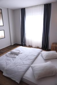a large white bed in a bedroom with a window at Gold Apart Otel in Mersin