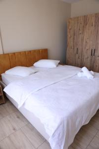 a large white bed with two pillows on it at Gold Apart Otel in Mersin