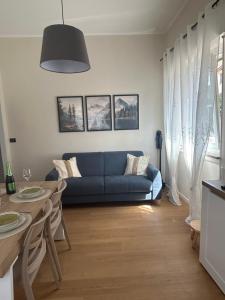 a living room with a blue couch and a table at Maris Home in Luino