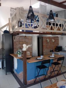 a loft kitchen with a blue island with two chairs at Sweet Hampton w Kacku in Gdynia