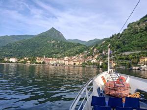 a boat on a body of water with mountains in the background at Maris Home in Luino