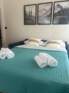 two beds with towels on top of them at Maris Home in Luino