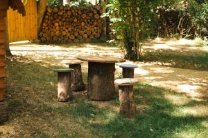 a table and stools in the grass with logs at Cabane Mushroom in Vouillé
