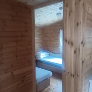a room with two beds in a wooden cabin at Liepsna Šventoji in Šventoji