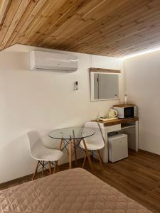 a bedroom with a table and chairs and a kitchen at Lukas Hotel in Muravitsa