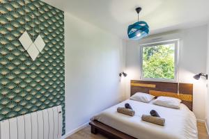 a bedroom with a bed and a window at Le Container de Jeff - Maison bois, grand jardin in Uzel