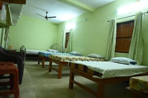 a row of beds in a room with at Bagan Bilas Homestay in Jhilimili