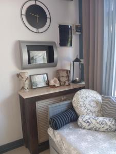 a living room with a clock and a chair at Sweet Hampton w Kacku in Gdynia