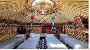 an interior of a yurt with couches in it at Keremet Yurt in Bokonbayevo