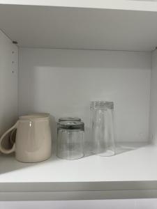 a shelf with three glass jars and a mug at Executive suite in Surrey +4 photos