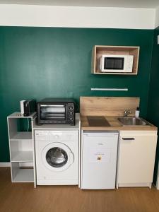 a kitchen with a washing machine and a microwave at Studio cosy - inspiré de Capri in Bar-le-Duc