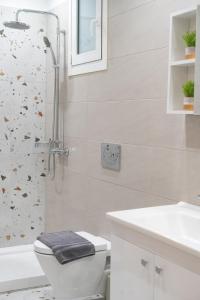 a bathroom with a shower and a toilet and a sink at Boho Nook Apartment in Rethymno +17 photos
