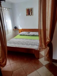 a bedroom with a bed with a green mattress at Studio apartman Hrast in Seline