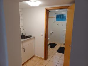 a small bathroom with a sink and a toilet at Moderne Ferienwohnung Am Goldberg in Neuleiningen +13 photos