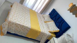 a blue bed with a yellow and white blanket on it at Appartement mansoria in Mansouria