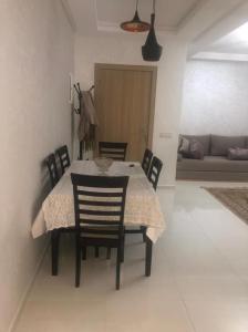 a dining room table and chairs in a living room at Appartement mansoria in Mansouria