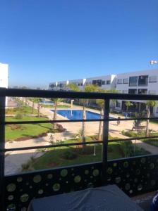 a balcony with a view of a pool and a building at Appartement mansoria in Mansouria