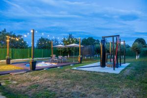 a playground in a park at night with lights at Kuća za odmor Fjaka in Sotin