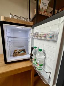 an open refrigerator with two bottles of water in it at Sabes Ferienwohnung in Altglandorf +50 photos