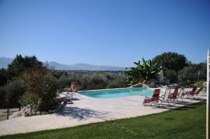 a swimming pool with chairs and a lawn at Il Maniero in Cassino