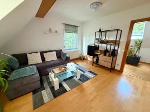 a living room with a couch and a glass table at Sabes Ferienwohnung in Altglandorf