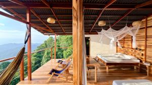a bedroom with a bed and a hammock on a deck at Minca Sintropia - Sustainable Lodge & Organic Coffee Finca in Minca +43 photos