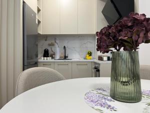 a vase of purple flowers sitting on a table at Stan na dan - SResidence Banja Luka in Banja Luka