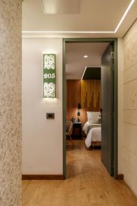 a hotel room with a bed and a door leading to a bedroom at Sloh Hotel & Bar Manila Medellin in Medellín