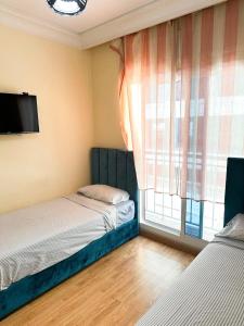 a bedroom with two beds and a window at super appartement centre avec parking in Tangier