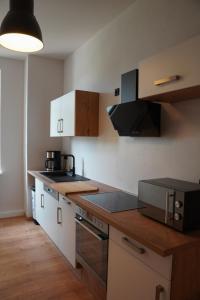 a kitchen with white cabinets and a counter top at Altstadtquartier Grimma in Grimma