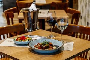 a table with a bowl of food and two glasses of wine at Sloh Hotel & Bar Manila Medellin in Medellín