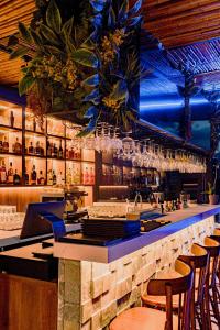 a bar with a counter with chairs and glasses at Sloh Hotel & Bar Manila Medellin in Medellín