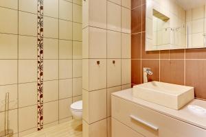 a bathroom with a sink and a toilet at Villa Arkodes in Gdańsk