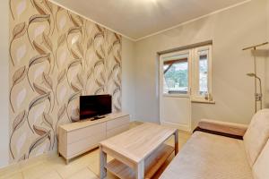 a living room with a tv and a couch at Villa Arkodes in Gdańsk