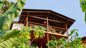 a building with a roof with plants in front of it at Minca Sintropia - Sustainable Lodge & Organic Coffee Finca in Minca