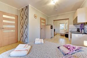 a bedroom with a bed with two towels on it at Villa Arkodes in Gdańsk